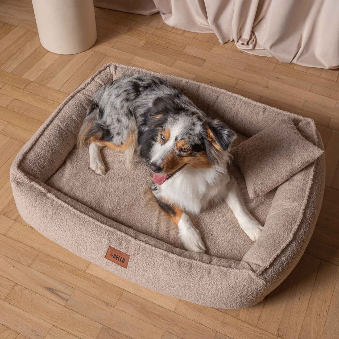 Hund som sover i en mjuk beige hundbädd i bouclé från ByBello