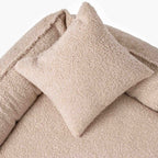 Närbild på mjukt beige bouclétyg och välfyllda kanter i hundbädden ROYAL